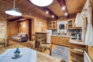 eine Küche und ein Wohnzimmer mit einem Tisch und Stühlen in der Unterkunft Chata Brusnica in Litmanová