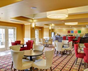 a restaurant with tables and chairs and a bar at Comfort Inn & Suites Fort Smith I-540 in Fort Smith