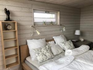 a room with a bed with pillows and a window at Villa Olympia in Höganäs