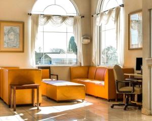 a living room with orange furniture and windows at Comfort Inn Watsonville in Watsonville