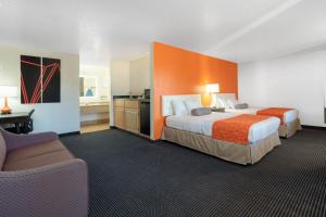 a hotel room with two beds and a chair at Howard Johnson by Wyndham Holbrook in Holbrook