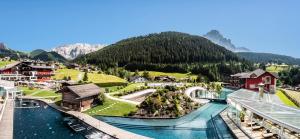 a view of a town with a river and mountains at Hotel Alpenroyal - The Leading Hotels of the World in Selva di Val Gardena