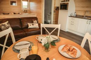 a table with two plates of croissants and flowers on it at Braeside Retreats in Thurso