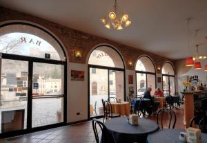 un ristorante con tavoli e sedie e grandi finestre di San Leo Albergo Diffuso a San Leo