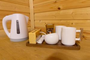 a wooden tray with cups and mugs on it at Cottage Shgedi in Mestia
