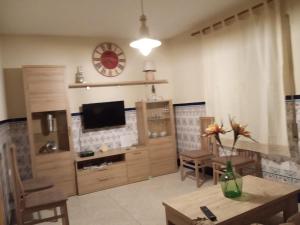 sala de estar con TV, mesa y sillas en Apartamento Turistico La Victoria en Trujillo