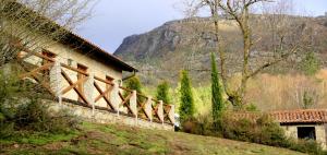 a building on a hill with a mountain in the background at Casa Natura Gerês in Campo do Gerês