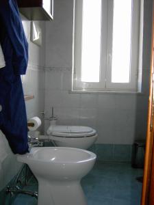 a bathroom with a toilet and a sink and a window at A wonderful penthouse in Naples in Naples