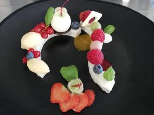 a letter k with fruit on a black plate at hoevehotel ter haeghe in Gistel