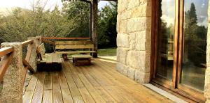 a wooden deck with a bench and a window at Casa Natura Gerês in Campo do Gerês