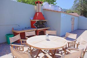 a patio with a table and chairs and a stove at Marilena Sunset Villa 2 in Ayia Marina