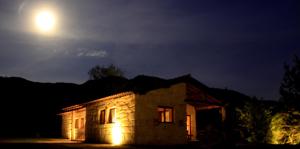 a house at night with the moon in the sky at Casa Natura Gerês in Campo do Gerês