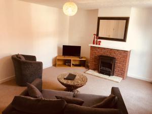 a living room with a couch and a fireplace at Vermuyden Apartment in Epworth