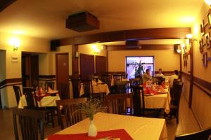 a restaurant with tables and chairs with people sitting at them at Pensiunea Blanca in Reghin