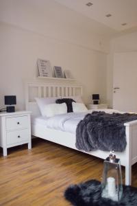 um quarto com uma cama branca e um cobertor preto em NEW Center Apartments em Niš