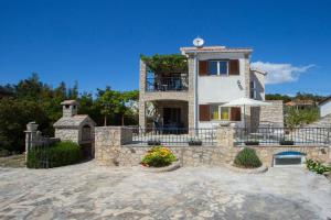 ein großes Haus mit einer Steinmauer und einem Balkon in der Unterkunft Apartments Ana - quiet and peaceful in Maslinica