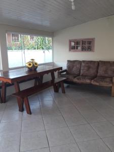 a living room with a wooden table and a couch at Pousada Viva Serra in Urubici