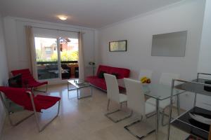 a living room with a red couch and chairs at Casares del Sol Ground Floor Apartment in Casares