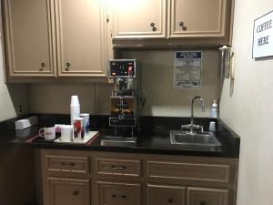 a kitchen counter with a coffee maker and a sink at Heritage House Inn in Muleshoe