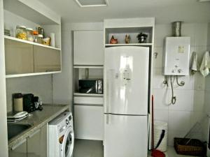 a white kitchen with a refrigerator and a stove at Apartamento Alto Padrão 3 quartos Iberostate Praia do Forte in Praia do Forte