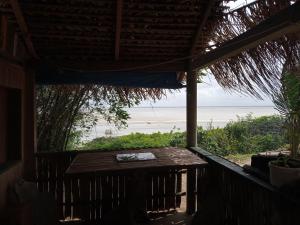 a porch with a table and a view of the ocean at La Luna Fortalezinha in Algodoal