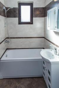 a bathroom with a white tub and a sink at Rodopsko Katche in Alamovtsi