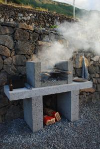 a stone table with a grill in front of a stone wall at Atlantic Window in Terra Alta