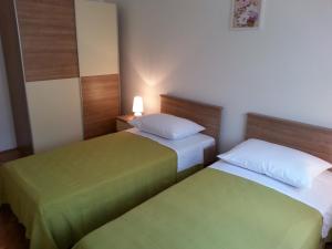 - 2 lits dans une chambre de couleur verte et blanche dans l'établissement Apartment Branko-with parking, à Vinišće