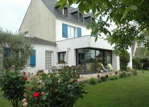 a white house with blue windows and a yard at Chambre D'Hôtes Mont D'Hermine in Arradon