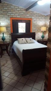 a bedroom with a large bed with two tables and two lamps at Chales Jack & Jill in Pipa