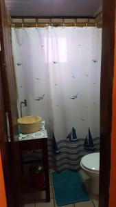 a bathroom with a shower curtain with a sink and a toilet at Chales Jack & Jill in Pipa +47 photos