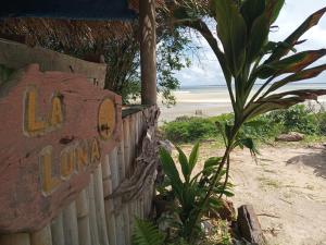 a sign on a fence next to a beach at La Luna Fortalezinha in Algodoal +3 photos