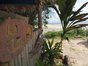 a sign on a fence next to a beach at La Luna Fortalezinha in Algodoal