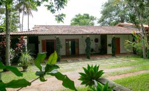a house in the middle of a garden at Eco Pousada Passaredo in São Miguel Arcanjo