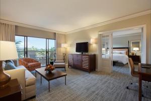 a hotel room with a bed and a living room at Fairmont Orchid Gold Experience in Waikoloa