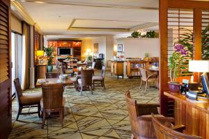 un restaurante con mesas y sillas y una cocina en Fairmont Orchid Gold Experience, en Waikoloa