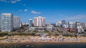 a group of people on a beach in front of a city at Enjoy Punta del Este in Punta del Este