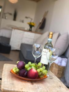 una bandeja de frutas y copas de vino en una mesa en A secret Oasis, en Eilat