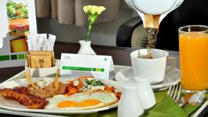 a breakfast plate with eggs and bacon and a cup of orange juice at Holiday Inn Tijuana Zona Rio, an IHG Hotel in Tijuana