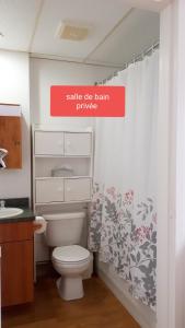 a bathroom with a white toilet and a sign that reads sell the bath privilege at MHotel Domaine l'Envolée- Maison Fleurie in Victoriaville