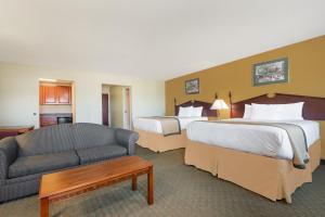 a hotel room with two beds and a couch at Days Inn by Wyndham Norton in Norton