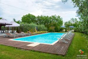 una piscina con terrazza e sedie intorno di Villa Helvetia a Corropoli