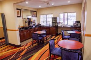 een kamer met tafels en stoelen en een keuken bij DUTCH INN AND SUITES in Orange City