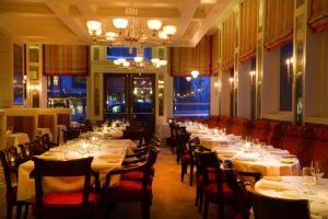Un comedor con mesas blancas y sillas rojas. en New Sheridan Hotel, en Telluride 20 fotos más