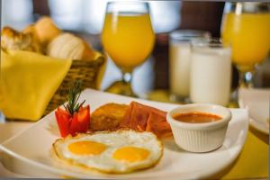 a plate of breakfast food with eggs and strawberries on a table at Airport Bed and Breakfast in Cancún
