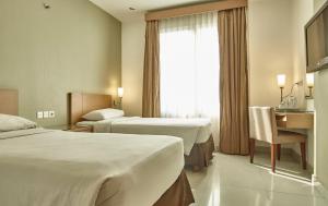 Postel nebo postele na pokoji v ubytování Triniti Hotel Jakarta
