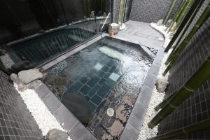 eine Aussicht über einen kleinen Pool mit Wasser in der Unterkunft Hotel Route Inn Grand Ueda Ekimae in Ueda