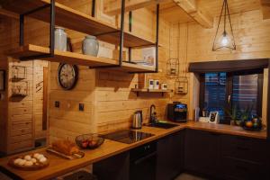 a kitchen with wooden walls and a counter with a sink at N°75- Na Uboczu in Krynica Zdrój