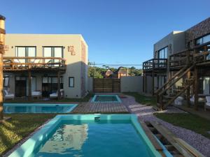 a pool in the backyard of a house with a building at LAS ESTEÑAS , casas del mar in La Pedrera
