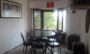 a dining room with a table and chairs and a window at Habitación en Casa Las Dos Nenas in Río Ceballos